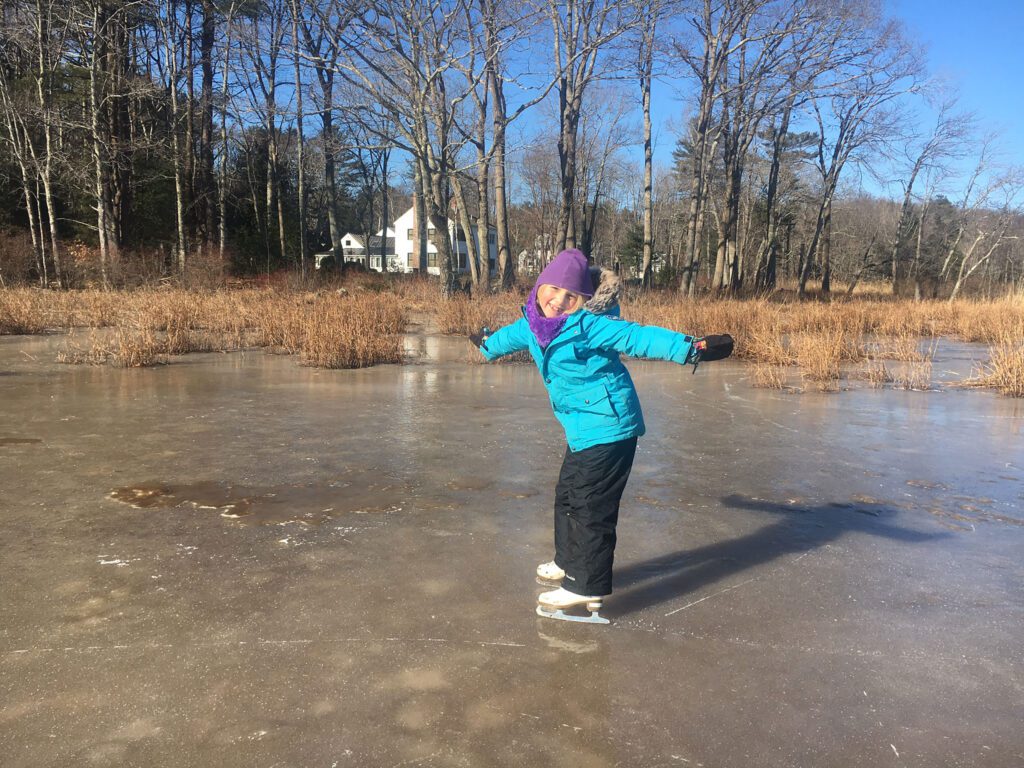 A child ice skating on a frozen marsh