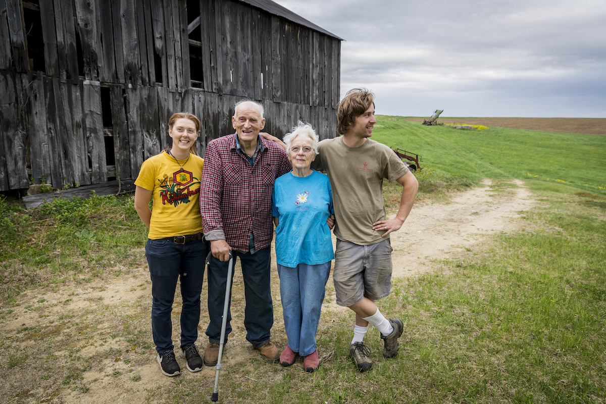 A group of people posing in front of a barn